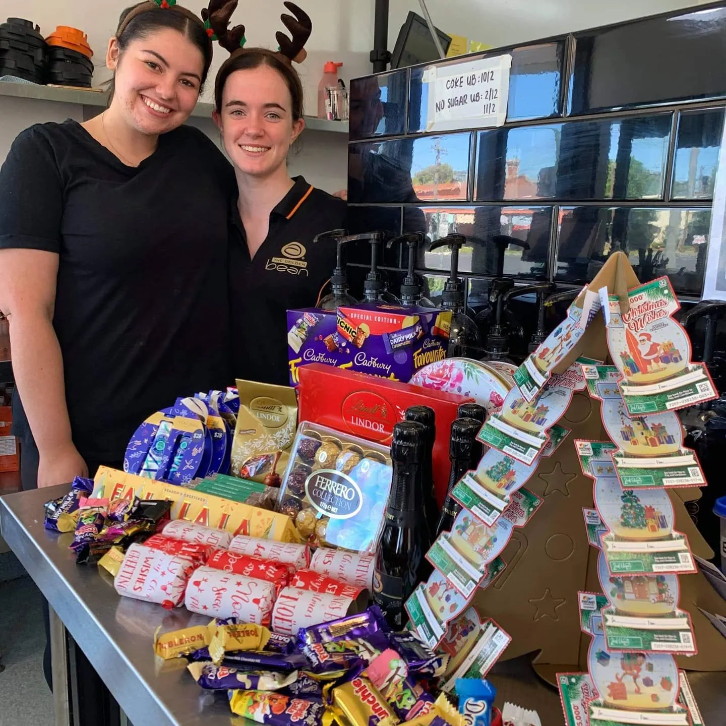 Two Golden Bean team members with Christmas gifts from customers